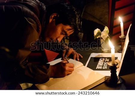 KATHMANDU, NEPAL - JANUARY 11, 2015: Man signing the condolences book at  the Cafe des Arts gathering in tribute to the victims of the terrorist attacks in Paris.