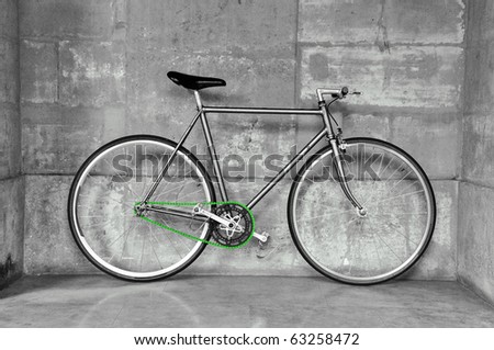 A fixed-gear bicycle (also called fixie) in black and white with a green chain