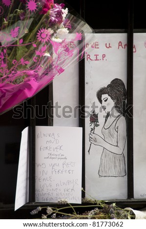 LONDON - JULY 27: Her fans pay tribute to Amy Winehouse in front of her house on Camden square, on July 27, 2011 in London. Amy Winehouse died aged 27 on Saturday, July 23.