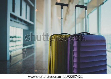 It’s time to explore. Two travel suitcases in empty departure terminal, blank space for your text message or design, vacation concept, suitcases in airport waiting area hall with big light windows