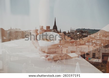 Double exposure with city and hands holding cup of coffee