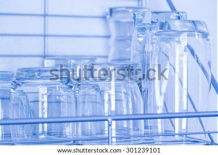 Lots of drink glasses on shelf, cold-tone  picture