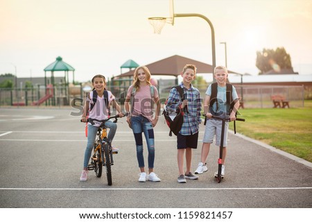 Group of smiling elementary school students on their way home. Back to school concept photo. Diverse group of real kids