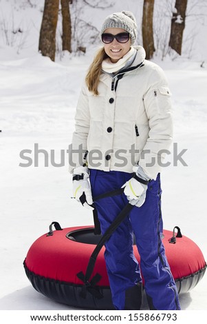Woman having fun going snow tubing on a winter day