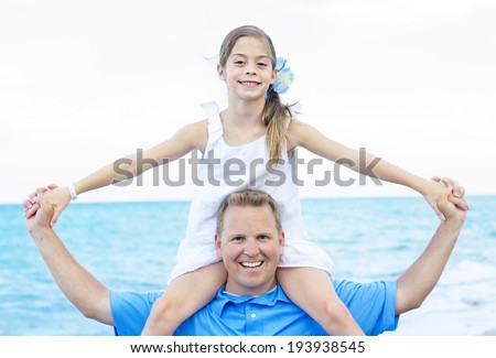 Daughter sitting on Fathers Shoulders at the Beach