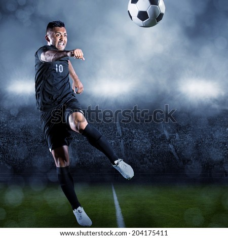 Soccer player kicking ball in a large stadium Soccer player kicking ball in a large stadium