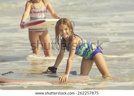 Cute Girl Playing in the Ocean on a boogie board