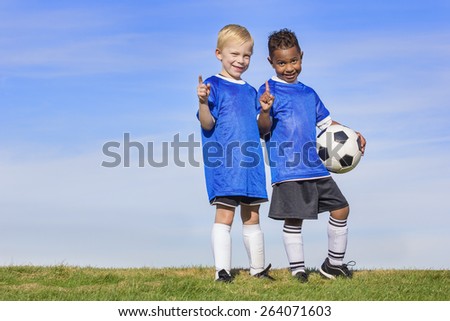 Two diverse young soccer players showing No. 1 sign. Full length view of two youth recreation league soccer players