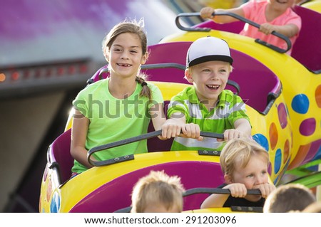 Boy and Girl on a thrilling roller coaster ride at an amusement park