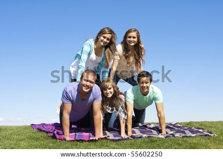 Young Friends Playing Outdoors making a human pyramid