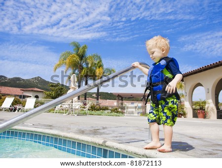 Little Boy Cautiously Stepping into Outdoor Pool in San Diego, California