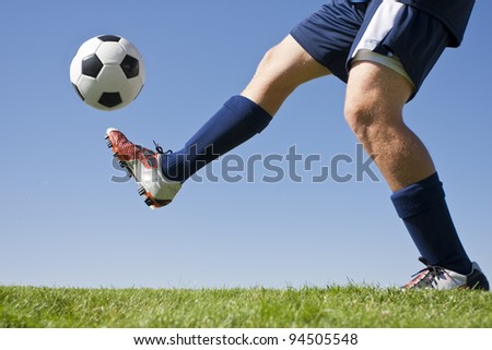 Athlete Kicking a soccer ball on field