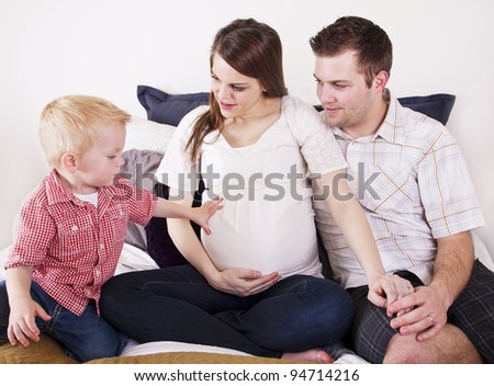 Boy touches his pregnant mother\'s big stomach