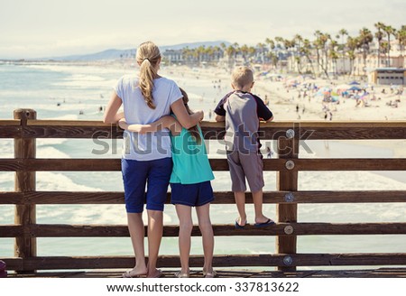 Young family hanging out on an ocean pier on vacation in Southern California