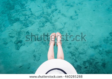 woman chilling sit on a clear blue ocean in Maldives with current texture