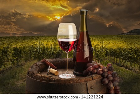 still life with red wine on background vineyard