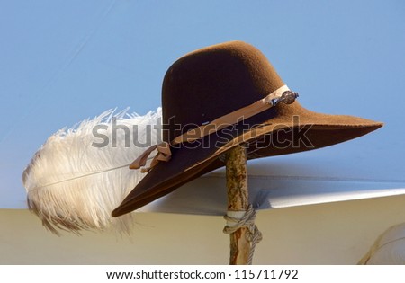 brown cowboy hat with a white feather attached
