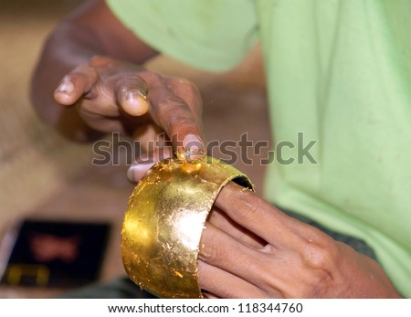 Traditional craft work attaching a layer of thin gold  to make lacquer ware