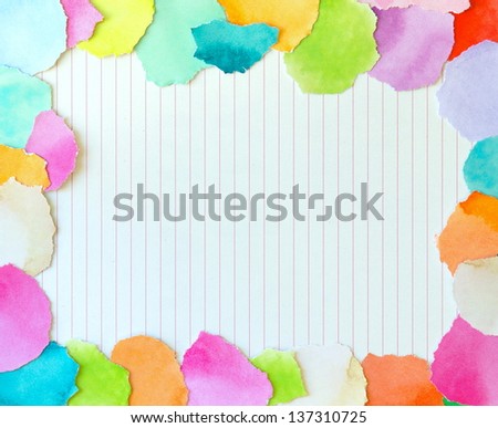 colorful border from torn pieces of paper surrounding a piece of writing paper