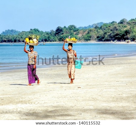 NGAPALI, MYANMAR - NOV.23;unidentified woman selling fresh fruit at the shoreline to tourists on Nov.23, 2012 Myanmar.Selling products to the tourists is the main income for people in Ngapali beach