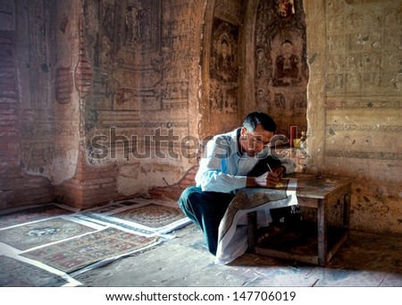 BAGAN, MYANMAR - FEBR. 4:Unidentified  man is painting replica artwork inside the Gawdawpalin Temple on februari 4 2013 Myanmar.There are over 300 monuments in Bagan which has mural paintings inside.
