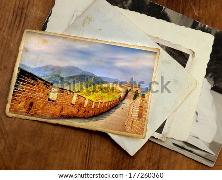 pile of old vintage photographs with on top a colorful image from the chinese wall of China