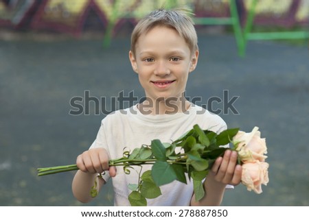 The boy on the street with flowers, presents flowers, smiling