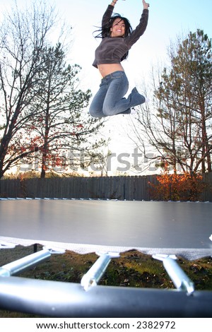 Attractive Young Woman Jumping on Trampoline and Having Fun in the Fall