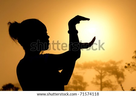 Female silhouette holding sun