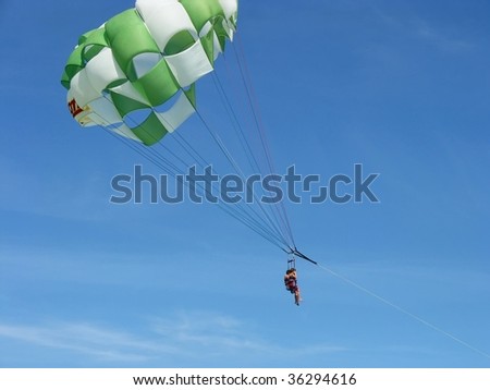 This is a parachutist flying behind the motor boat.
