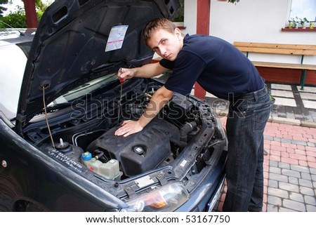 This is a car mechanic next to the engine of small city car