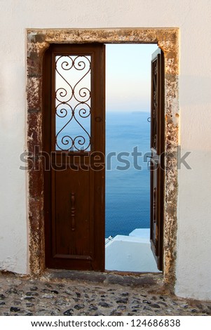 Wooden doors open up access to the sea. Greece, Santorini island