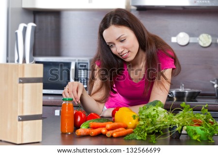 Beautiful, young woman and vegetables in the domestic kitchen