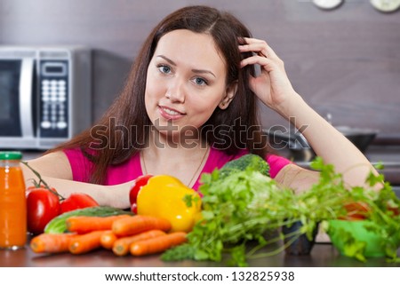 Beautiful, young woman and vegetables in the domestic kitchen