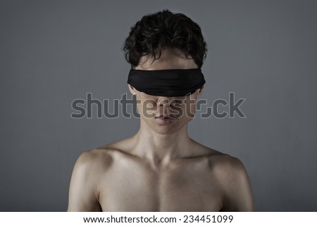 Young man of Asian appearance with a blindfold
