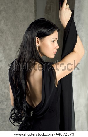 Beautiful woman in a black dress with the bared back