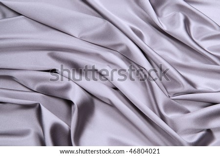 Wavy background from a silk fabric of silvery color
