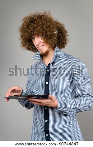 The young guy with a curly hair listens to music