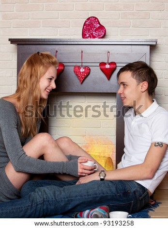 Young couple sitting by the fireplace in the st. Valentine's day