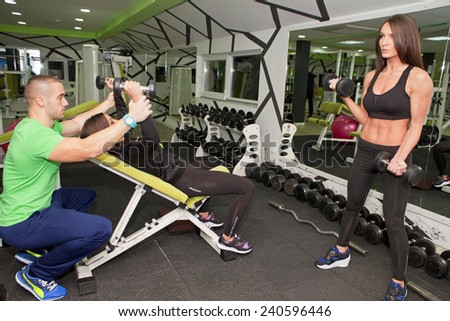 In the gym - man and women are exercising in the gym