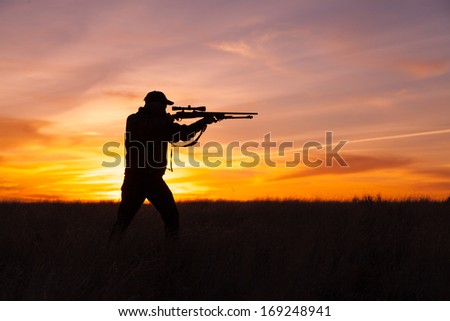 Rifle Hunter Silhouetted In Beautiful Sunset
