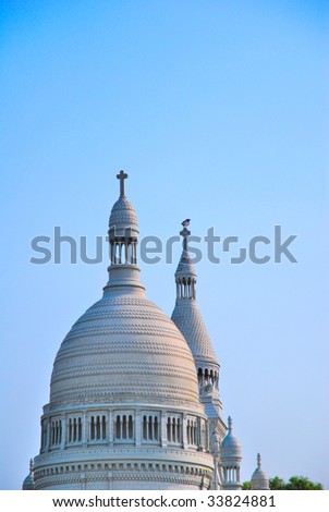 White, European style church architecture with bird perched on roof