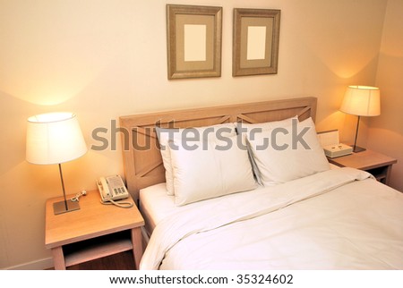 Twin beds with table lamps lighted up in a high class, dimly-lit hotel room