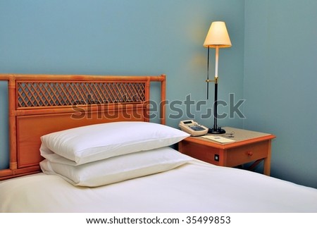 Table at bedside with phone and writing materials in hotel room