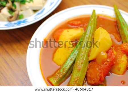 Home cooked Chinese vegetarian curry. Ingredients include potatoes, lady fingers, and tomatoes. Suitable for food and beverage, travel, healthy lifestyle, and diet and nutrition.