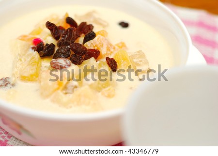 Fruit salad made from a variety of fruits, topped with raisins and soya bean milk for breakfast. Suitable for diet and nutrition, healthy eating and lifestyle, and food and beverage concepts.
