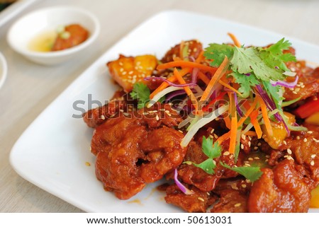 Chinese vegetarian sweet and sour pork cuisine. Ingredients include deep fried mock meat and peppers. Suitable for food and beverage, healthy lifestyle, and diet and nutrition.