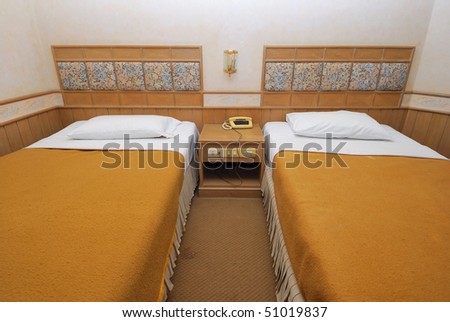 Twin beds neatly done up in a high class hotel room. Suitable for concepts such as travel, tourism, vacation and holiday.