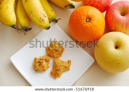 Contrast of fruits and unhealthy snack to signify concepts such as healthy lifestyle, diet and nutrition, and food and beverage.