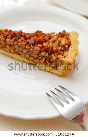 Hazel nut tart with fork on white plate. For concepts such as food and beverage, diet and nutrition, and healthy eating.